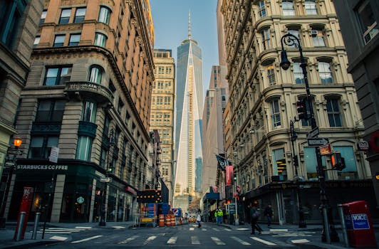 Street view of One World Trade Center in New York City surrounded by urban architecture and city life.